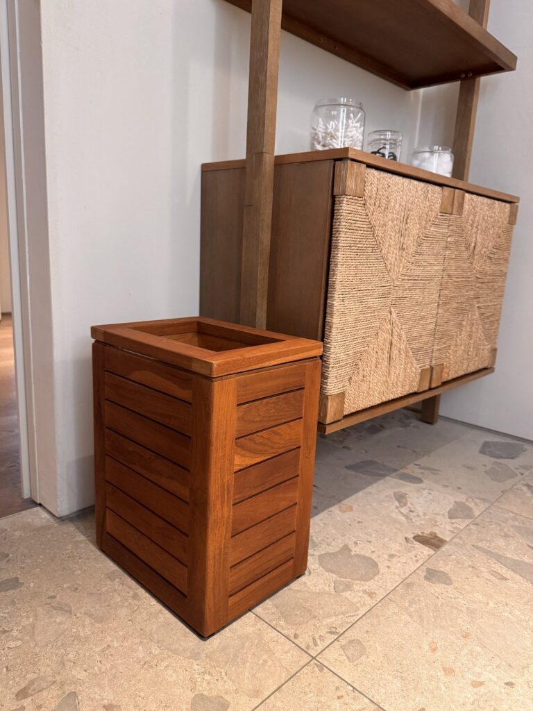 The wooden garbage can in the bluSONIL studio bathroom with its liner perfectly tucked out of sight