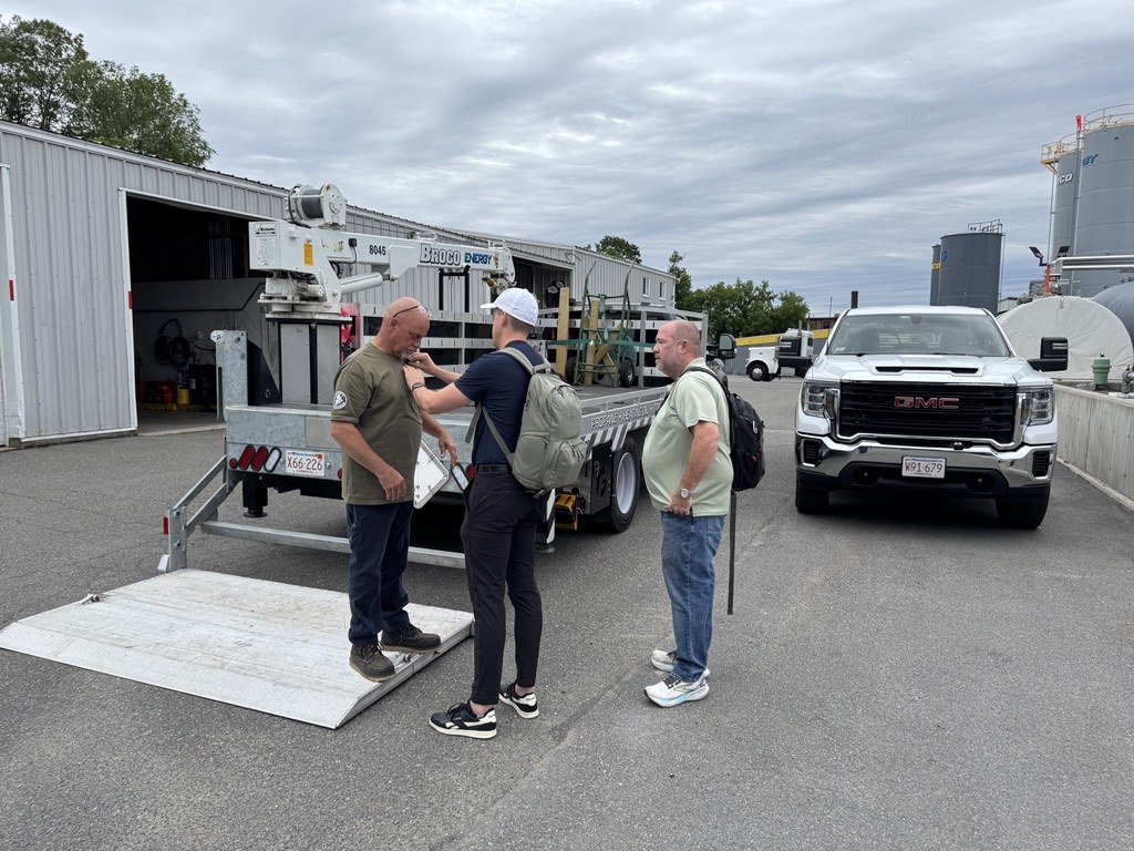 On location at a client media shoot, walking the site next to the branded trucks and trailer
