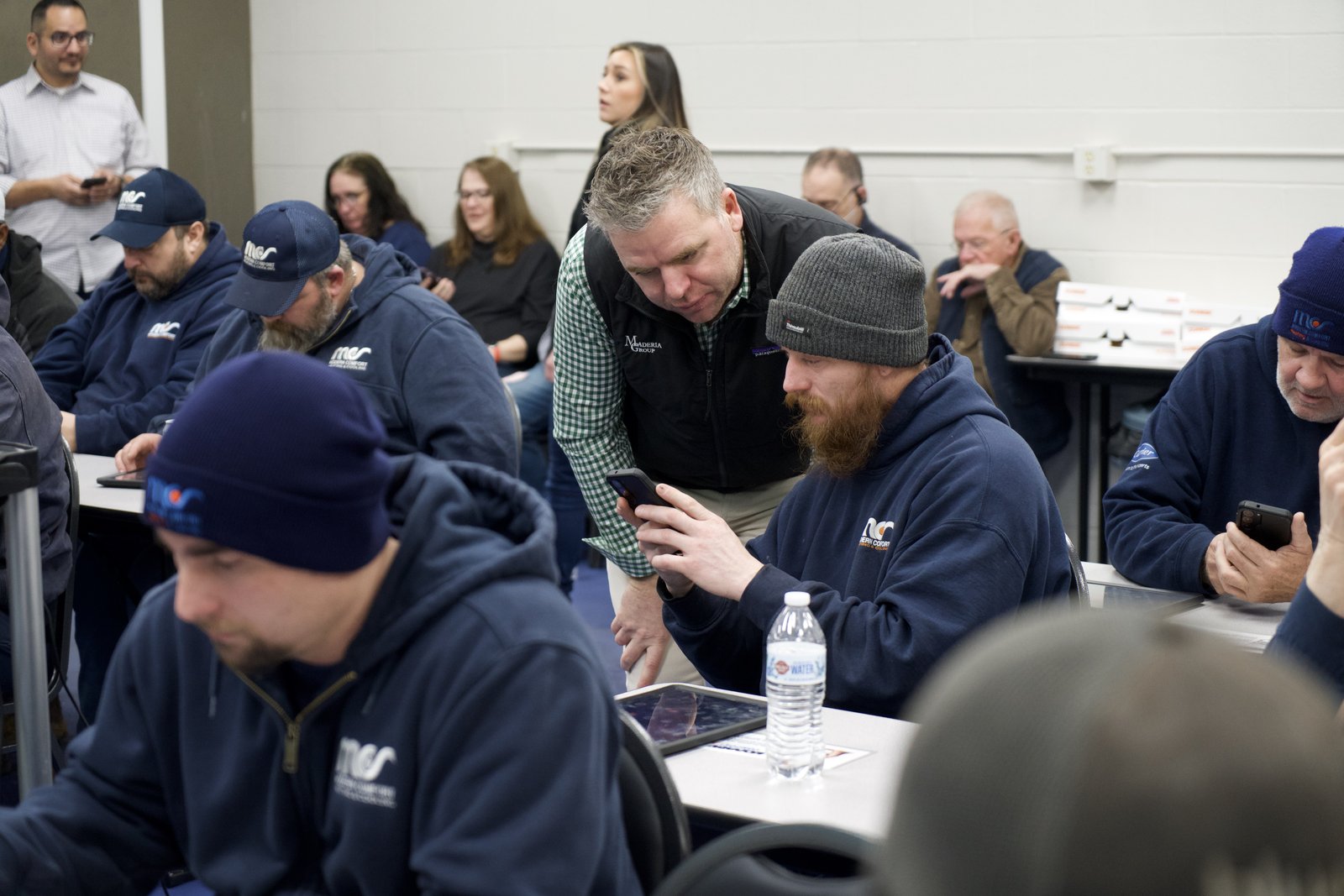 Navara co-founder Andrew Maderia helping technicians set up the review platform on their phones during a training session