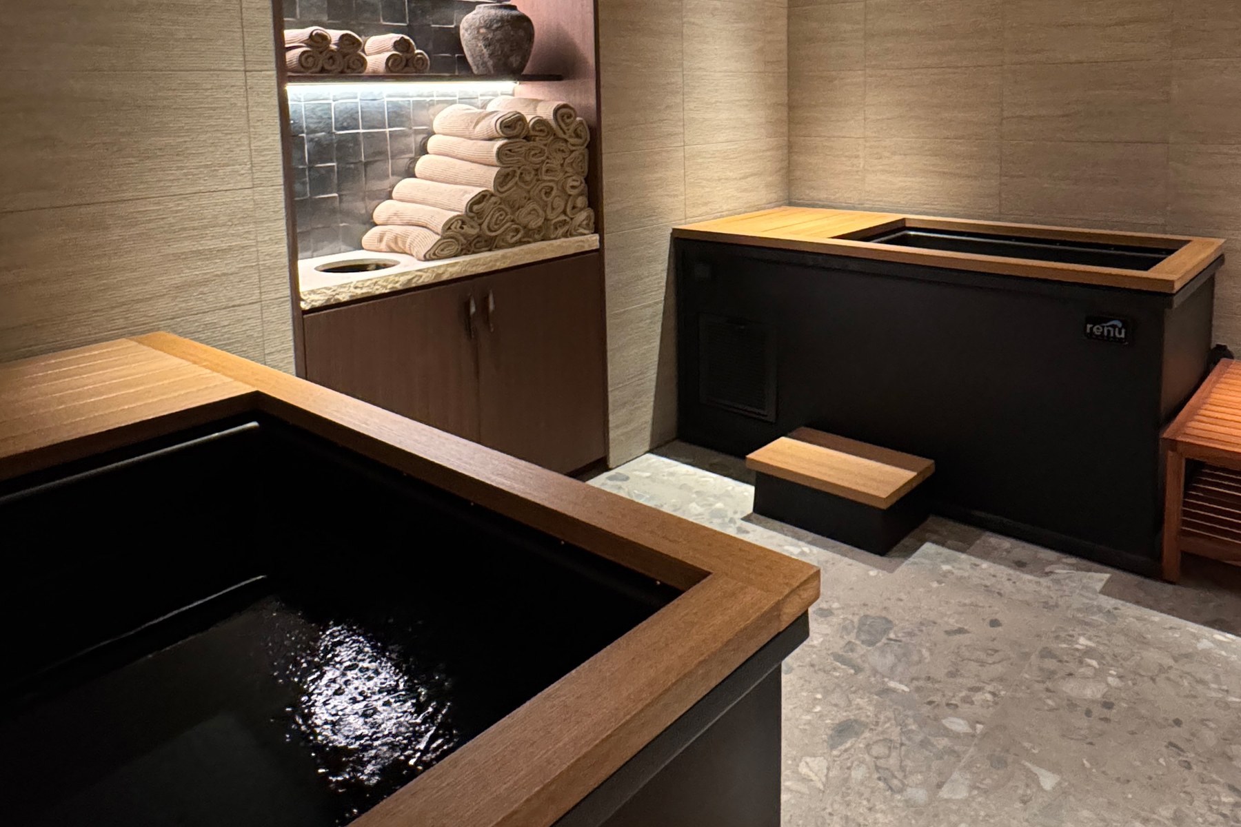 The contrast therapy room at bluSONIL, with two cold plunge tubs and stacked towels